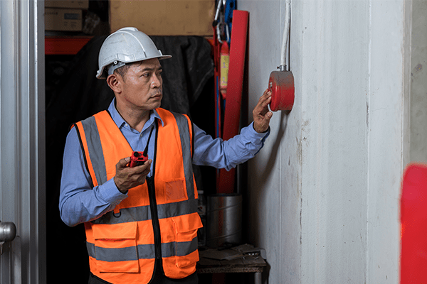 Man inspecting a fire alarm