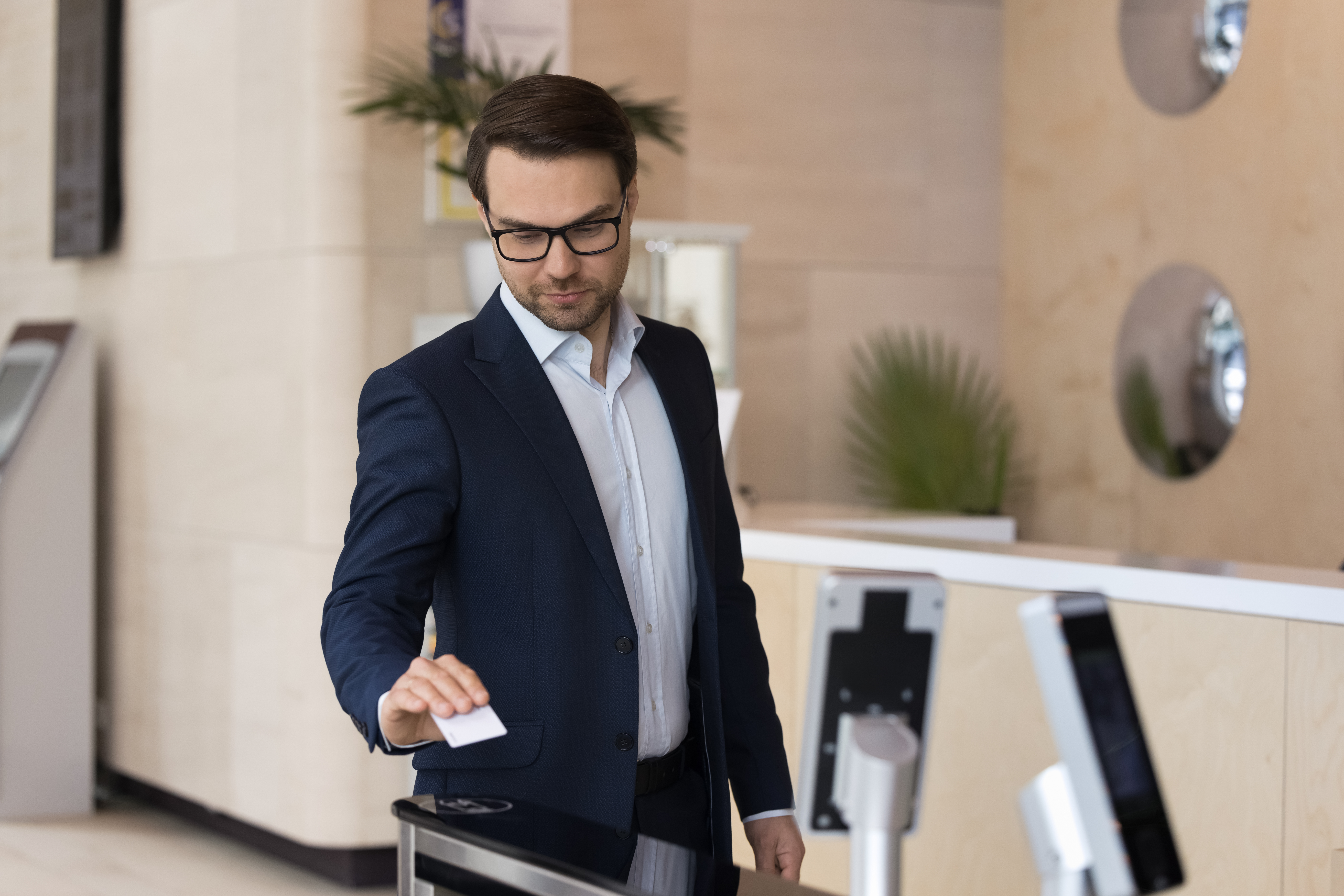 Businessman using pass card open automatic gates in modern office