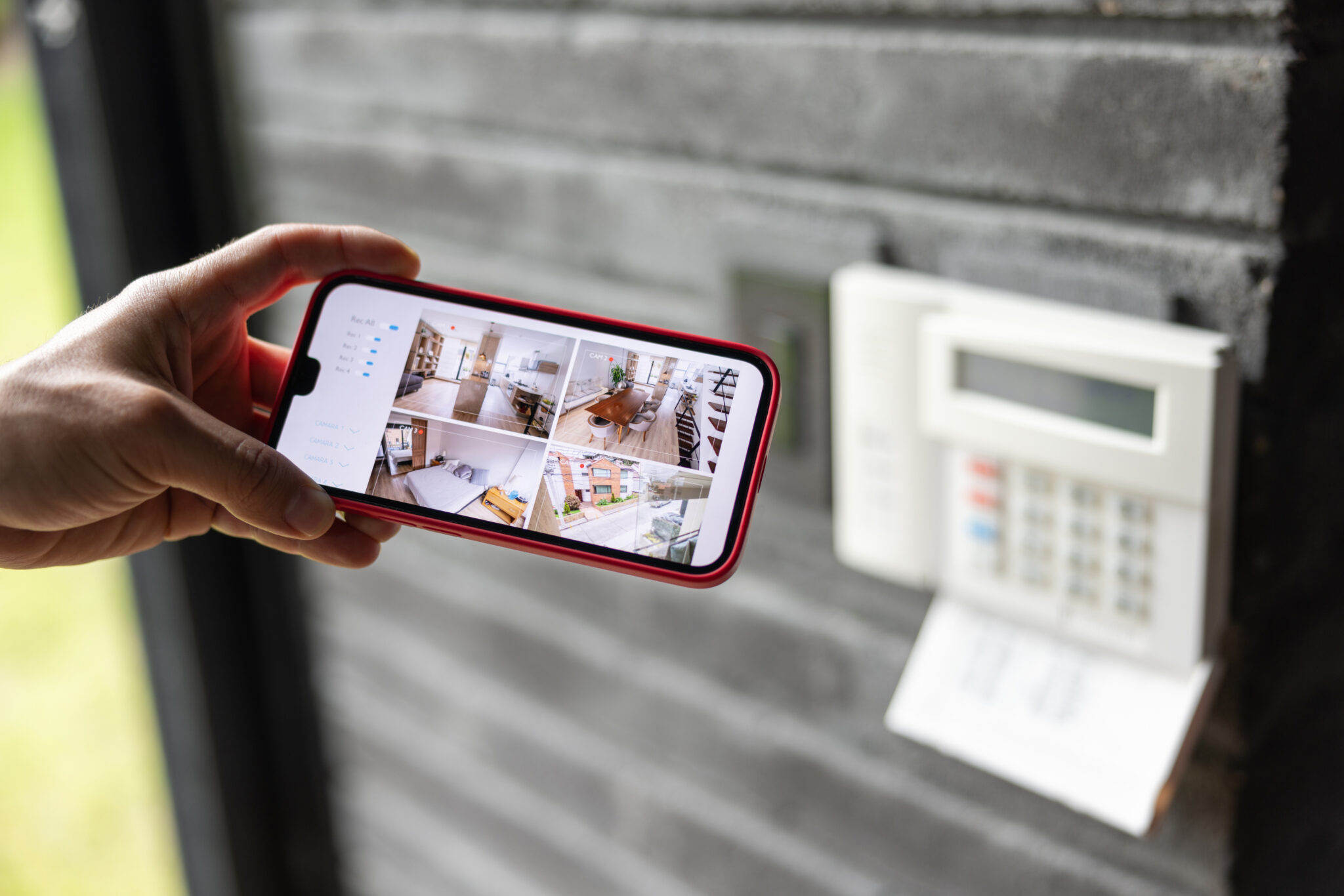 Man watching the security cameras of her house in her cell phone
