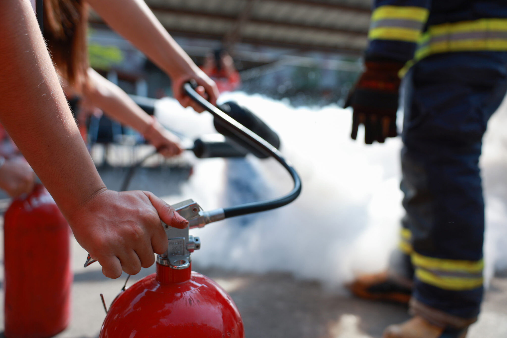 Employees firefighting training, Concept Employees hand using fire extinguisher fighting fire closeup